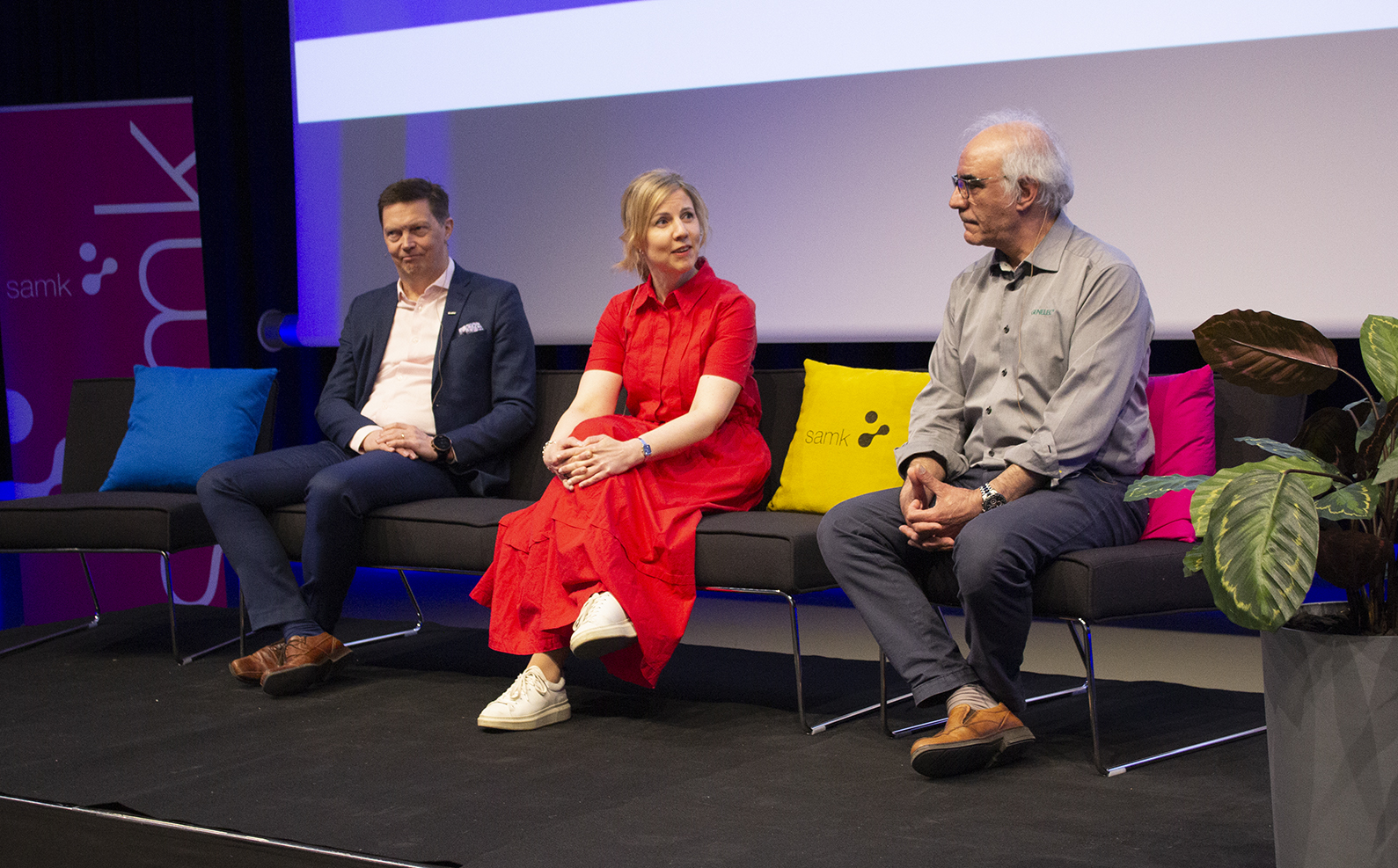 Genelec CEO Siamäk Naghian, Boliden Development Director Vesa Törölä and Project Director Katariina Yrjönkoski from University Consortium of Pori sit on a sofa in a panel discussion.