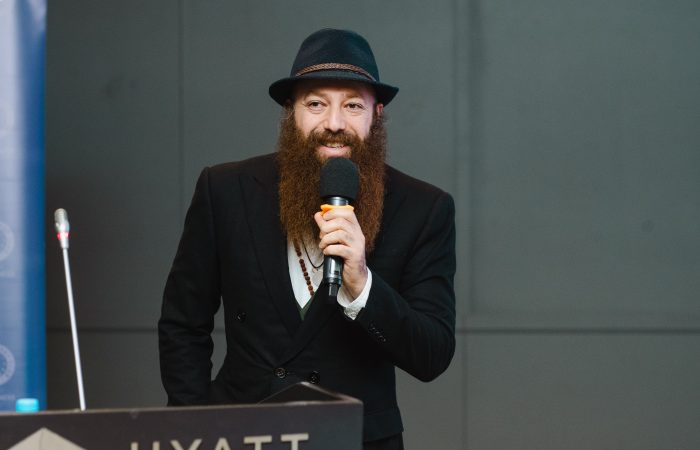 Parrakas mies puhumassa mikkiin.