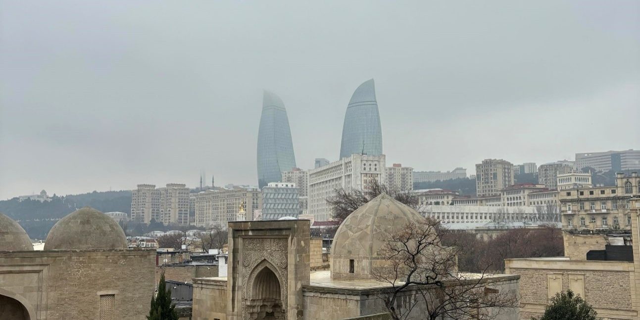 LEF Kuva2 Picture from Baku. There is old building in the front of the picture and far on the background there is two skyscrapers.