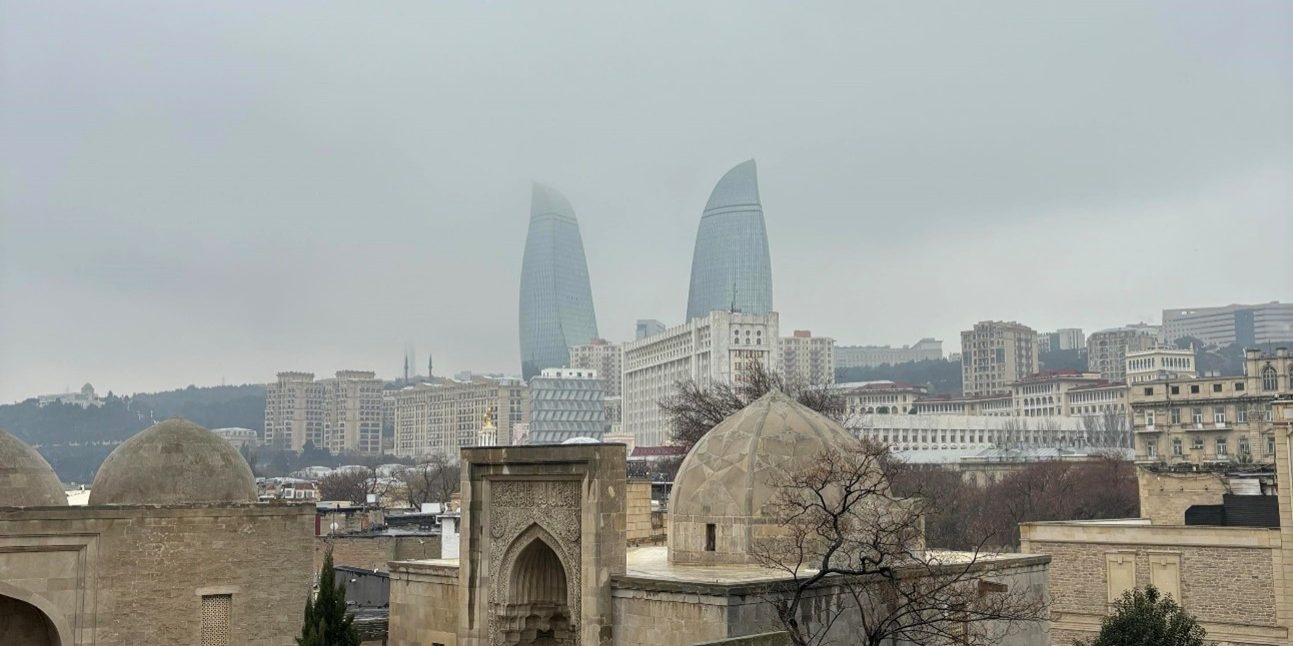 Kuva Bakusta, jossa etualalla vanha rakennus ja taustalla sumun keskellä kaksi pilvenpiirtäjää.