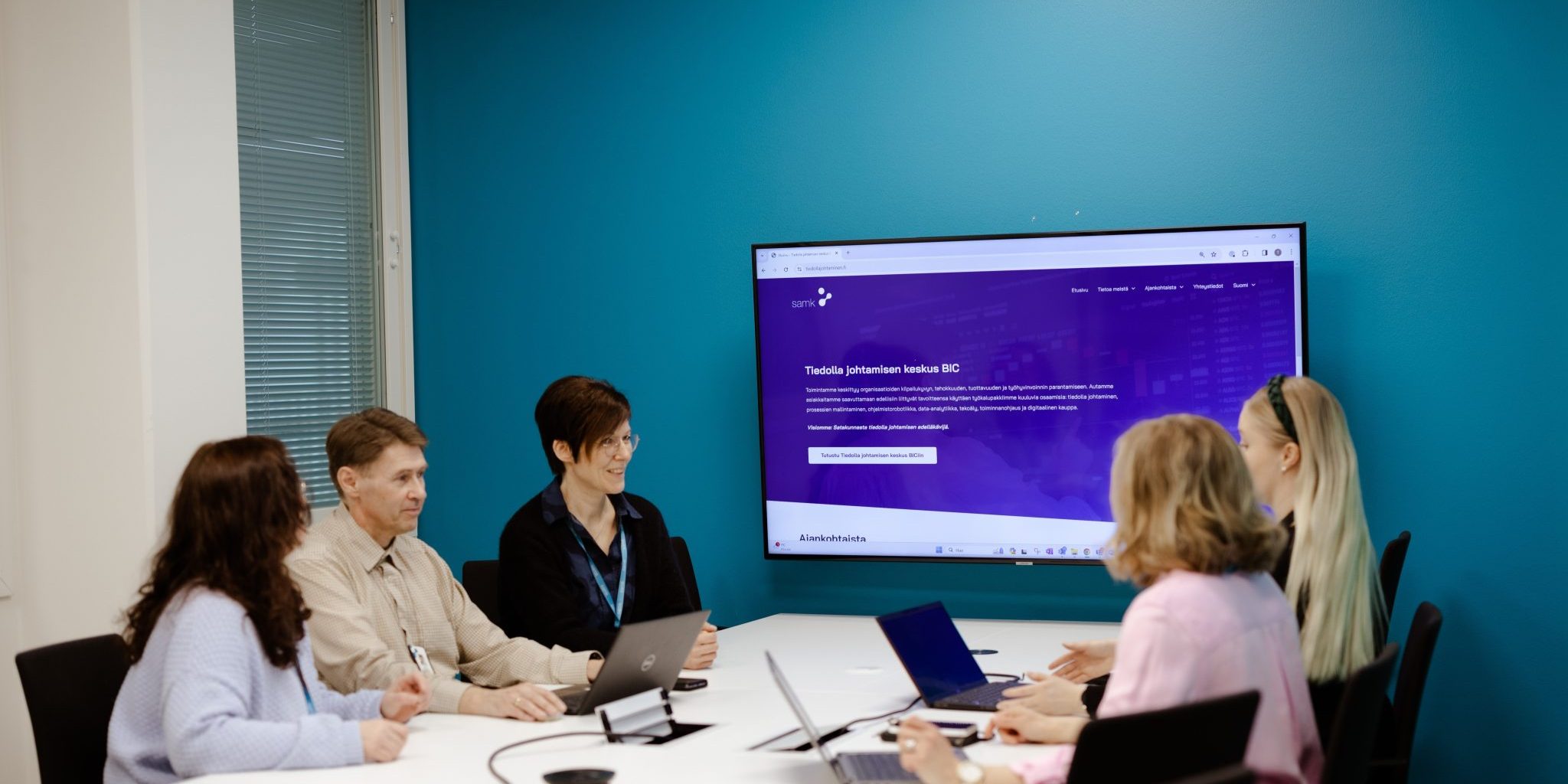 Five people sitting at a table in a conference room.