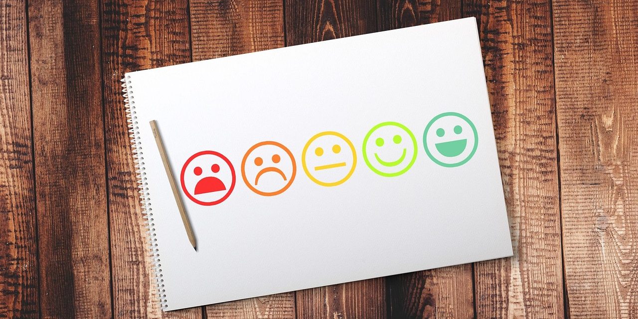 Kuvituskuva, jossa paperille piirrettynä hymynaamoja riviin surullisesta iloiseen.